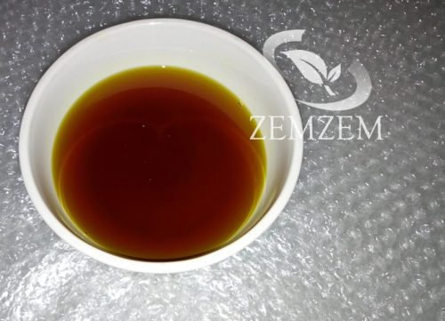 Dark-red, premium cold-pressed Ethiopian black seed oil after gravity settling